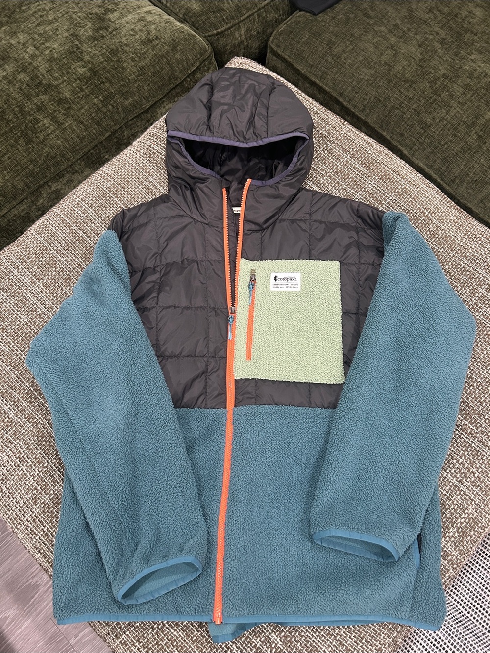 cotopaxi Teal Fleece Jacket with Black Puffer Hood and Light Green Chest Pocket